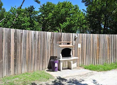 Espace barbecue au charbon de bois dans le parc du camping Tastesoule dans le Médoc