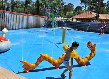 Enfant jouant dans l'espace jeu de la piscine du camping Tastesoule près de Montalivet