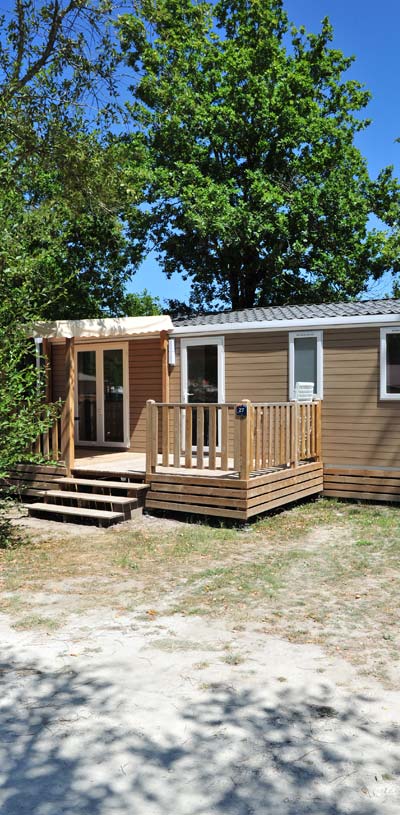 Mobil-home avec terrasse et grand arbre au  camping Tastesoule dans le Médoc