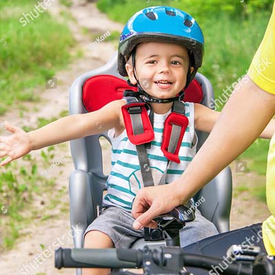 Jeune enfant dans un siège bébé  de vélo en location au camping Tastesoule à Vensac