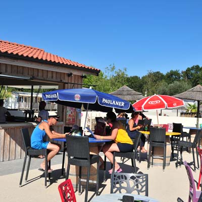 Tables du bar et vue ensoleillée au camping Tastesoule à Vensac